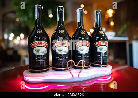 LVIV, UCRAINA - 26 OTTOBRE 2022: Baileys Irish Cream quattro bottiglie di vetro su uno stand di marca con illuminazione Foto Stock