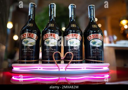 LVIV, UCRAINA - 26 OTTOBRE 2022: Baileys Irish Cream quattro bottiglie di vetro su uno stand di marca con illuminazione Foto Stock