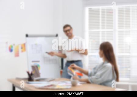 Vista sfocata dei designer di interni professionisti che lavorano in ufficio Foto Stock