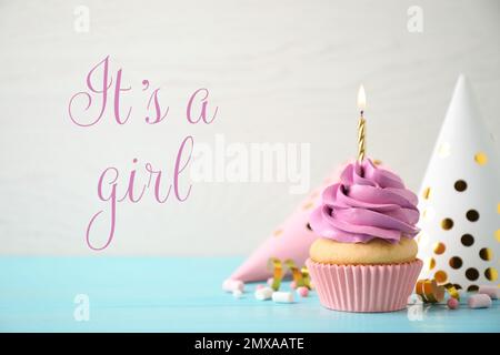 Cupcake dell'acquazzone del bambino con la candela per la ragazza sullo sfondo chiaro Foto Stock