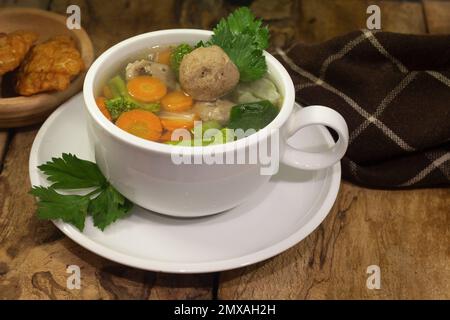 zuppa di verdure e polpette con contorno tempeh su vecchio sfondo di legno Foto Stock