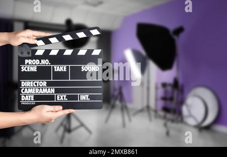 Assistente che tiene il clapperboard sulla posizione della ripresa, primo piano. Produzione cinematografica Foto Stock