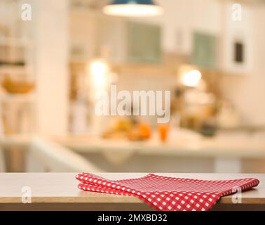 Asciugamano rosso su tavolo in legno in cucina. Spazio per il testo Foto Stock