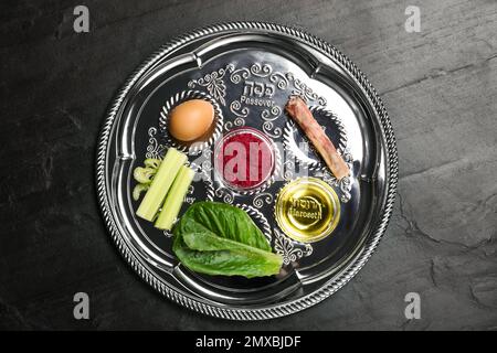 Piastra di protezione Passover (keara) su tavolo nero, vista dall'alto. Festa di Pesah Foto Stock