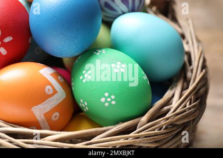 Cestello con colorate le uova di Pasqua su tavola, primo piano Foto Stock