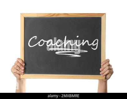 Apprendimento per adulti. Donna con lavagna con parola Coaching su sfondo bianco, primo piano Foto Stock