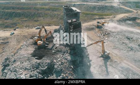 Escavatori con martello idraulico che demoliscono un edificio industriale. Foto Stock