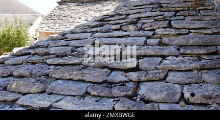 tegole grigio pietra da un edificio medievale per sfondo di pietre grigie Foto Stock