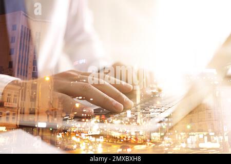 Doppia esposizione del programmatore maschio con laptop e cityscape, primo piano Foto Stock