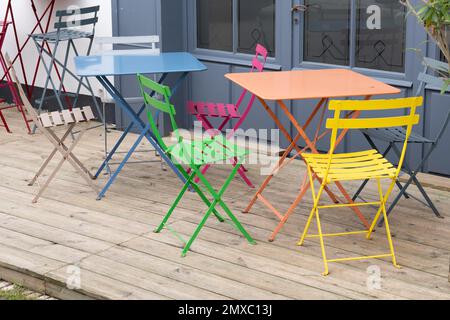 sedia colorata in metallo nella terrazza estiva in legno Foto Stock