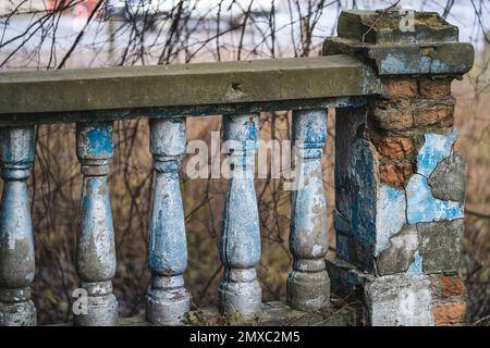 una balaustra sulla ringhiera di una vecchia scala incrinata Foto Stock