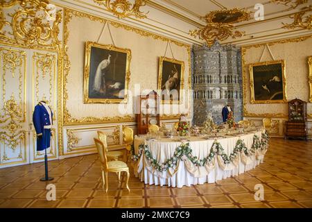 White Dining Room, Catherines Palace, Tsarskoye Selo, Russia. Pareti bianche con ornamento dorato, con scaldabagno in ceramica blu e bianca. Foto Stock