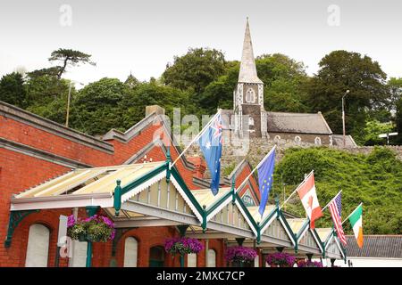 Terminal delle navi da crociera in mattoni rossi e centro storico decorato con bandiere del mondo e museo di Cobh che si trova all'interno della chiesa scozzese, Cobh, vicino a Cork, Irlanda Foto Stock