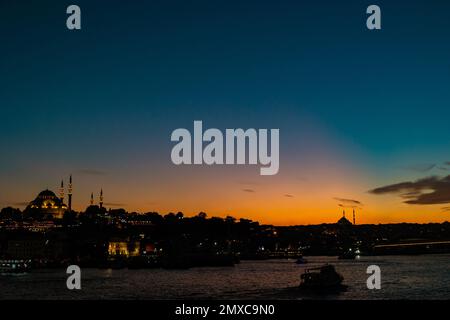 Vista di Istanbul al tramonto con il cielo arancione e blu. Concetto islamico foto. Corno d'Oro e moschee. Foto Stock