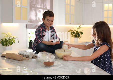 I bambini piccoli cute cucinano l'impasto in cucina a casa Foto Stock