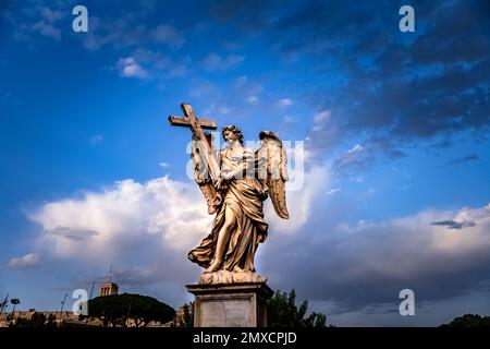 Una statua d'angelo di marmo che sorregge la croce sul St. Angelo Bridge a Roma Foto Stock