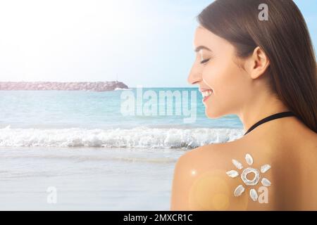 Donna con crema solare sulla schiena in spiaggia, spazio per il testo Foto Stock