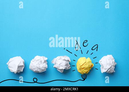 Concetto di idea. Palline di carta stropicciate, disegno della lampadina e spazio per il testo su sfondo blu, giacitura piatta Foto Stock