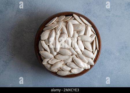 Una ciotola piena di semi di zucca, vista dall'alto Foto Stock