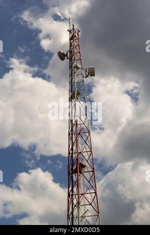 Torre di telecomunicazione per telefono cellulare con antenne su un cielo blu. Funzione di distribuzione dei telefoni cellulari a contratto. Foto Stock