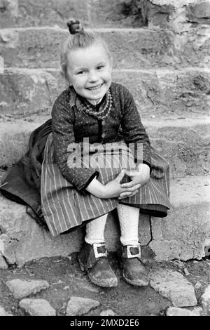 Porträt eines Mädchens in der Tracht des Schwalm-Eder-Kreises in Hessen, Germania, 1938. Ritratto di una ragazza che indossa il vestito tradizionale della regione di Schwalm-Eder in Assia, Germania, 1938. Foto Stock