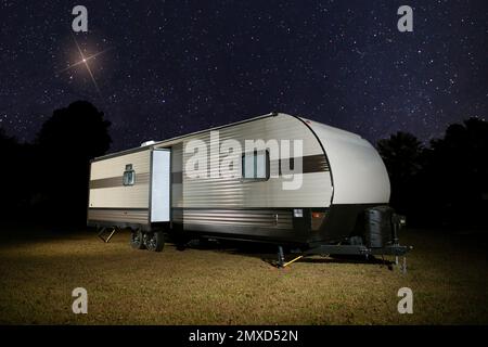 Stella di Natale che sorge sopra un rimorchio da campeggio in una notte buia Foto Stock