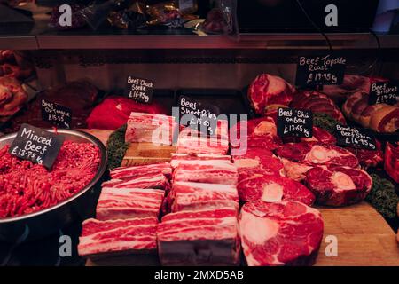 Varietà di carne e prodotti a base di carne in vendita presso uno stand del mercato alimentare a Londra, Regno Unito. Foto Stock