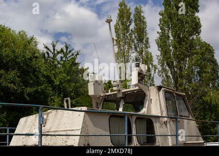 Vecchia barca abbandonata, nave sulla riva sullo sfondo di alberi e fiume. Foto Stock