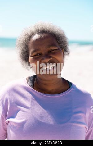 Primo piano ritratto di sorridente afroamericana senior woman con capelli corti grigi godendosi in spiaggia Foto Stock