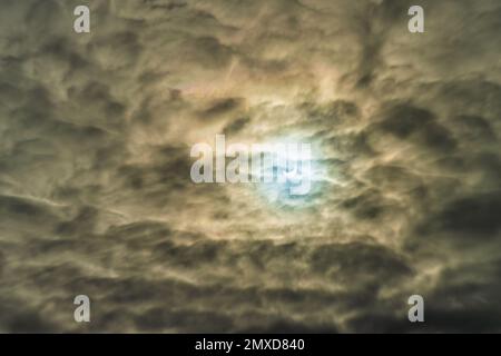 Eclissi solare parziale passando dietro le nuvole drammatiche. Foto Stock