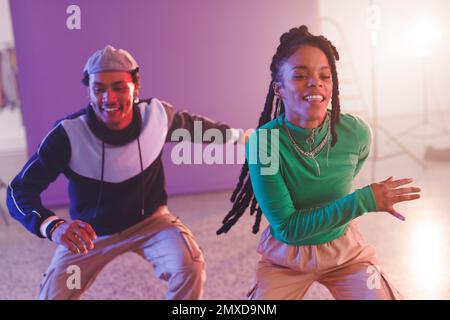 Immagine di ballerine hip hop femminili e maschili felici e diverse in studio. Danza, ritmo, movimento e concetto di allenamento. Foto Stock