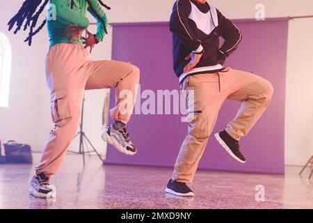 Immagine della sezione bassa di diverse ballerine hip hop femminili e maschili in studio. Danza, ritmo, movimento e concetto di allenamento. Foto Stock