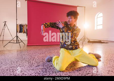 Immagine della ballerina biraciale maschile hip hop in studio. Danza, ritmo, movimento e concetto di allenamento. Foto Stock