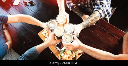 Gruppo di amici che brinda con la birra nel pub, vista dall'alto. Design del banner Foto Stock