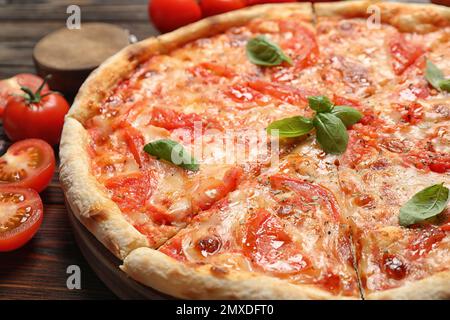 Deliziosa pizza Margherita su tavolo in legno, vista sul primo piano Foto Stock