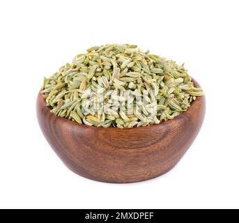 Semi di finocchio in ciotola di legno, isolato su fondo bianco. Grani di finocchio verde. Spezie ed erbe aromatiche Foto Stock
