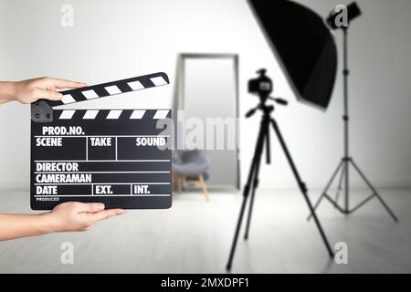 Assistente che tiene il clapperboard sulla posizione della ripresa, primo piano. Produzione cinematografica Foto Stock