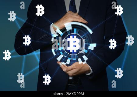 Concetto FinTech. Uomo d'affari che dimostra lo schema con simboli bitcoin Foto Stock