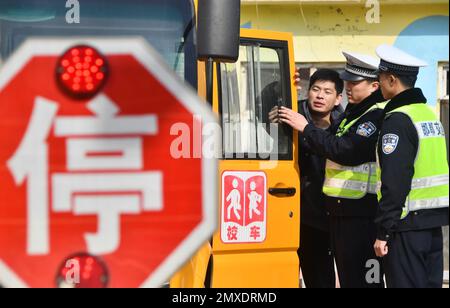 HANDAN, CINA - 3 FEBBRAIO 2023 - gli ufficiali di polizia effettuano controlli di sicurezza sugli autobus scolastici a Handan, provincia di Hebei, Cina settentrionale, 3 febbraio 2023. Foto Stock