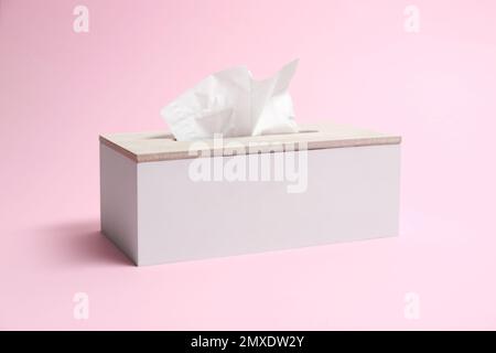 Supporto con fazzolettini di carta su sfondo rosa Foto Stock