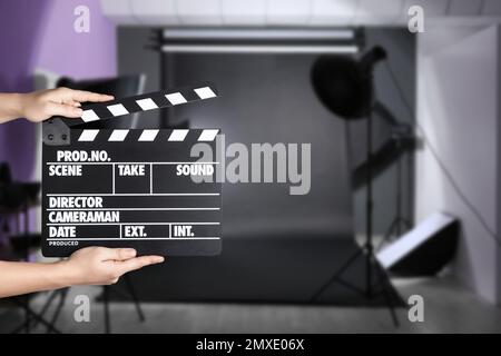 Assistente che tiene il clapperboard sulla posizione della ripresa, primo piano. Produzione cinematografica Foto Stock