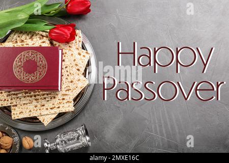 Composizione piatta con pezzi di pesach tradizionale (Passover Seder) su tavolo grigio Foto Stock