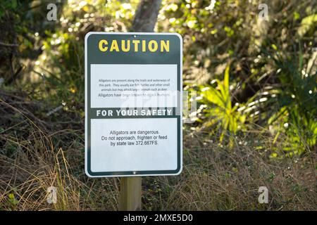 Alligatori segnale di avvertimento nel parco statale della Florida per la prudenza e la sicurezza durante il percorso a piedi Foto Stock