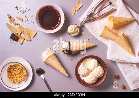 Gelato fatto in casa e cioccolato con noci durante il processo di cottura, vista dall'alto. Vita ferma culinaria con piatto Foto Stock