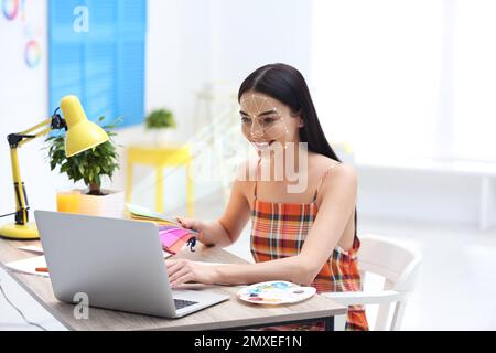 Sistema di riconoscimento facciale. Donna che utilizza un notebook in ufficio Foto Stock