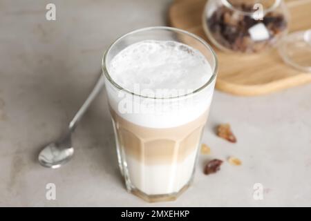Delizioso latte macchiato in vetro su tavolo grigio Foto Stock