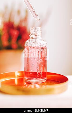 Pipetta e flacone trasparente con siero, gel, olio o altro prodotto cosmetico. Prodotto di bellezza trendy per la cura del corpo con peptidi, ceramidi, acido ialuronico. Foto Stock