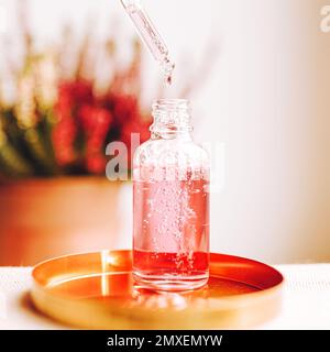 Pipetta e flacone trasparente con siero, gel, olio o altro prodotto cosmetico. Prodotto di bellezza trendy per la cura del corpo con peptidi, ceramidi, acido ialuronico. Foto Stock