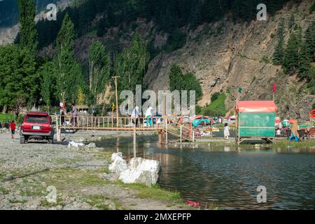 Gente pakistana che si gode l'aria fresca sul fiume in estate, Swat Valley, Pakistan Foto Stock