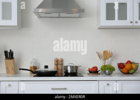 Bancone con set di stoviglie, utensili e prodotti in elegante cucina interna Foto Stock